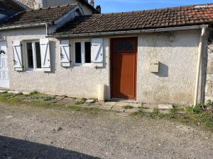 a small white house with a red door at Petite maisonnette proche de Giverny in Bonnières-sur-Seine