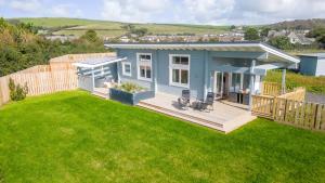 a small blue house with a large yard at Croftner, Great Field Lodges in Braunton