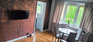 sala de estar con mesa y TV en la pared en Apartament Loft, en Toruń