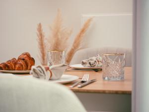 uma mesa com um prato de pão e dois copos em Op Oost Boutique hotel & Restaurant het Kook Atelier em Oosterend