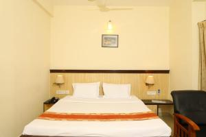 Pokój hotelowy z łóżkiem i krzesłem w obiekcie Hotel Shrie Shaanth w mieście Selam