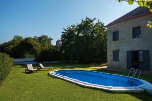 una piscina en un patio junto a una casa en Apartamentos Redondela - A Casa da Praia, en Redondela