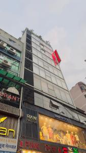 um edifício alto com uma loja em frente em Hotel Prime Inn Mirpur 10 em Dhaka