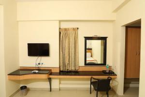 Cette chambre comprend un bureau avec un ordinateur et un miroir. dans l'établissement Hotel Shrie Shaanth, à Salem