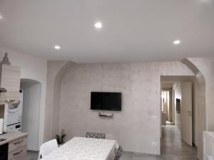 a white room with a bed and a tv on a wall at MIA GUEST ROOM in Triggiano