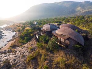 eine Luftansicht eines Hauses auf einem Hügel neben dem Meer in der Unterkunft Madwaleni River Lodge - Babanango Game Reserve in Ulundi