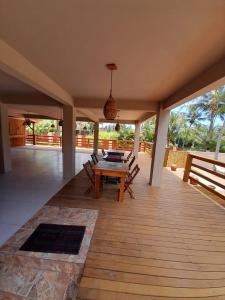 a patio with a wooden table and chairs on it at Casa Sol do Gostoso in São Miguel do Gostoso