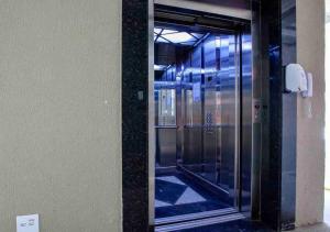 a glass door of a elevator in a building at JARDIM DAS PALMEIRAS II - HOME RESORT in Ubatuba
