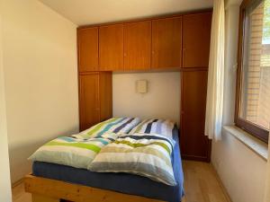 a bed in a bedroom with wooden cabinets at Ferienhaus Marienleuchte in Marienleuchte