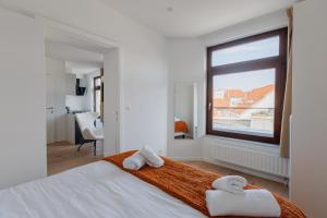 een slaapkamer met 2 handdoeken op een bed met een raam bij Sweet Inn - Bodeghem in Brussel