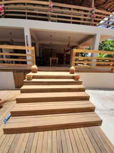 un escalier en bois avec des fleurs. dans l'établissement Casa Sol do Gostoso, à São Miguel do Gostoso