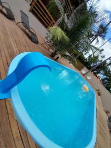 een blauw zwembad op een houten terras bij Casa Sol do Gostoso in São Miguel do Gostoso