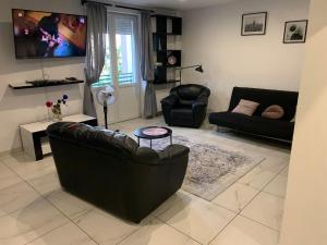 a living room with a leather couch and a chair at Green View Kotlarska in Wrocław