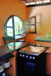a kitchen with a stove and a counter with a window at Casa Del Mar in Marau