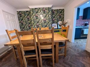 a wooden table and chairs in a kitchen with a wallpaper at The Limes - Stylish City Centre Retreat in Peterborough