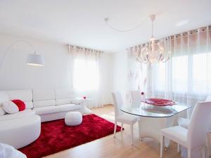 Sala de estar blanca con sofá blanco y mesa de cristal en La Perla Nel Borgo, en Cappella Maggiore