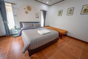 Un dormitorio con una cama y una mesa de madera. en Halo Sea Koh Larn, en Ban Phatthaya Nua