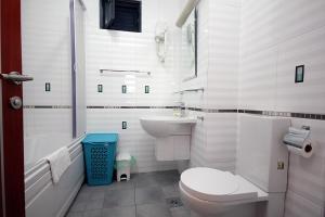 a white bathroom with a toilet and a sink at Plava Vila Beach Apartments Sveti Stefan in Sveti Stefan
