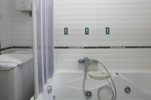 a white bathroom with a shower and a tub at Plava Vila Beach Apartments Sveti Stefan in Sveti Stefan