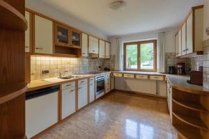 a kitchen with white cabinets and a large window at Haus Helena in Mellau