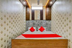 een slaapkamer met een bed met rode kussens bij A5 Hotel And Dormitory in Gorakhpur