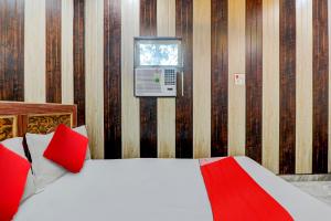 een slaapkamer met een bed met rode kussens en een raam bij A5 Hotel And Dormitory in Gorakhpur