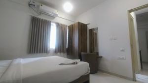 um quarto com uma cama branca e uma janela em Brand New Suite Room em Bangalore