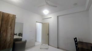 um quarto branco com um espelho e uma ventoinha de tecto em Brand New Suite Room em Bangalore