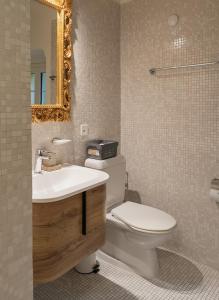 La salle de bains est pourvue de toilettes, d'un lavabo et d'un miroir. dans l'établissement Palazzo Branca - Unique experience, à Brissago