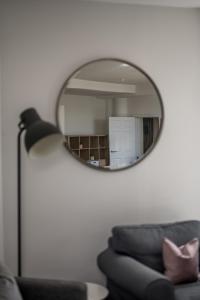 a mirror in a living room with a couch and a chair at Casa Fresa - Cowgate House in Dundee