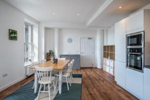 a kitchen and dining room with a wooden table and chairs at Casa Fresa - Cowgate House in Dundee