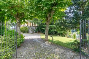 ein Tor zu einem Garten mit Bäumen und Gras in der Unterkunft Villa Harriet in Grandola ed Uniti