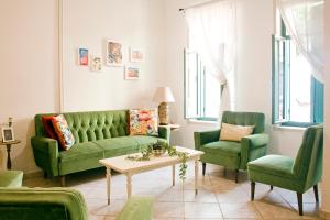 a living room with a green couch and two chairs at Lilian's House in Chania