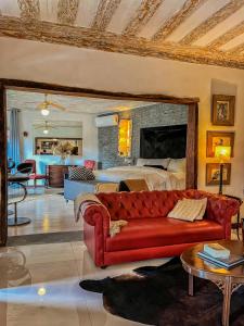 a living room with a red couch in front of a bed at Pousada Villa 3 Lagos in Santo Antônio do Pinhal