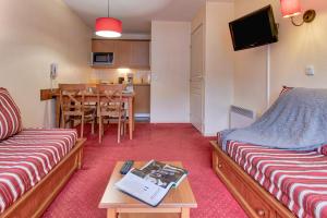 a room with two beds and a table with a table at Résidence Pierre & Vacances Les Rives de l'Aure in Saint-Lary-Soulan