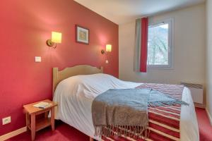 サン・ラリー・スランにあるRésidence Pierre & Vacances Les Rives de l'Aureのベッドルーム1室(赤い壁のベッド1台、窓付)