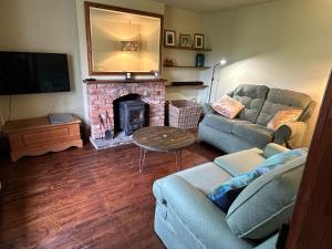 a living room with a couch and a fireplace at Fourways in Pewsey