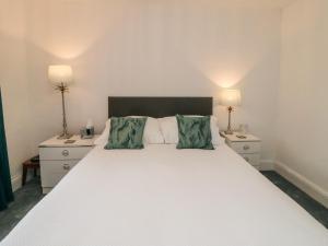 a bedroom with a large white bed with two night stands at Field Cottage in York