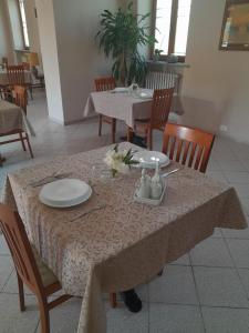 una mesa con un plato blanco encima en La Porta del Sole en Caselle Torinese