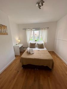 Un dormitorio con una cama grande y una ventana en Stunning House 15 min from Wembley arena, en Londres