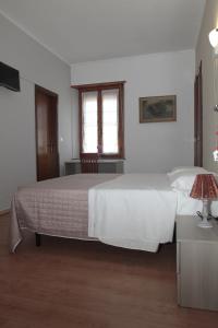 a bedroom with a large white bed and a window at La Porta del Sole in Caselle Torinese