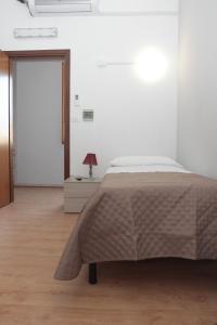 a white bedroom with a bed and a door at La Porta del Sole in Caselle Torinese