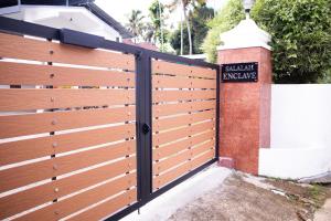 a wooden fence in front of a house at Altrove AC Studio Apartment in Cochin