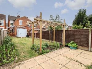 a wooden pergola in a backyard with a fence at 160 Canterbury Road in Colchester