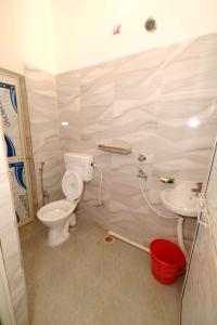 uma casa de banho com um WC e um lavatório em HOTEL SWASTIK "free pick up from station & airport" em Deoghar