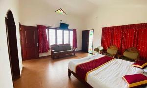 - une chambre avec un grand lit et des rideaux rouges dans l'établissement FabHotel Blossom Cottages, à Kodaikānāl