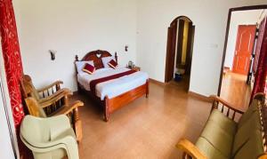 - une chambre avec un lit, une chaise et un canapé dans l'établissement FabHotel Blossom Cottages, à Kodaikānāl
