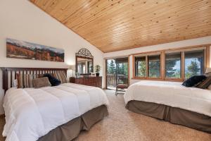 two beds in a bedroom with a wooden ceiling at The Gemstone Grand by Leavetown Vacations in Grand Lake