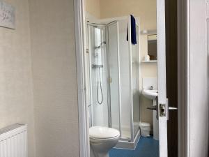 a bathroom with a toilet and a glass shower at Cavendish House in Weymouth