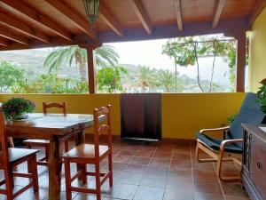 comedor con mesa, sillas y pared amarilla en Casa Tajonaje - Entorno rural en Alajeró